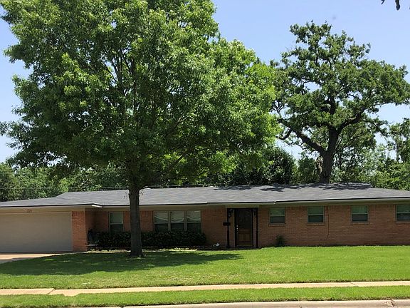 Another front view - new windows and new roof with lots of mature trees. Front yard has been soded with zoysia grass.
