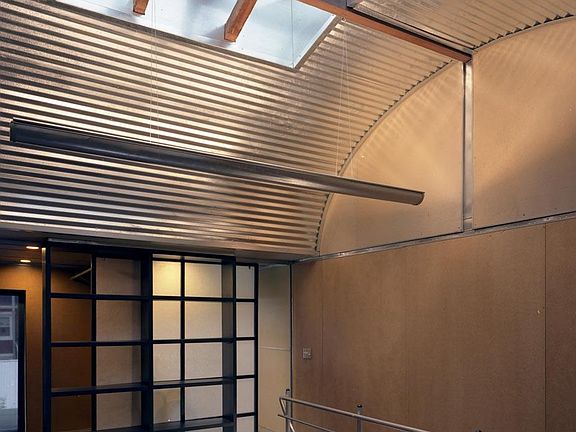 Vaulted metal ceiling with skylight and indirect lighting