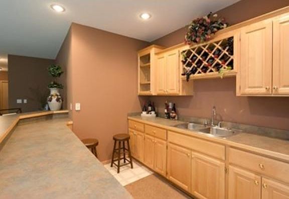 Full wet bar in lower with maple cabinets, wine rack, counter space and sink.