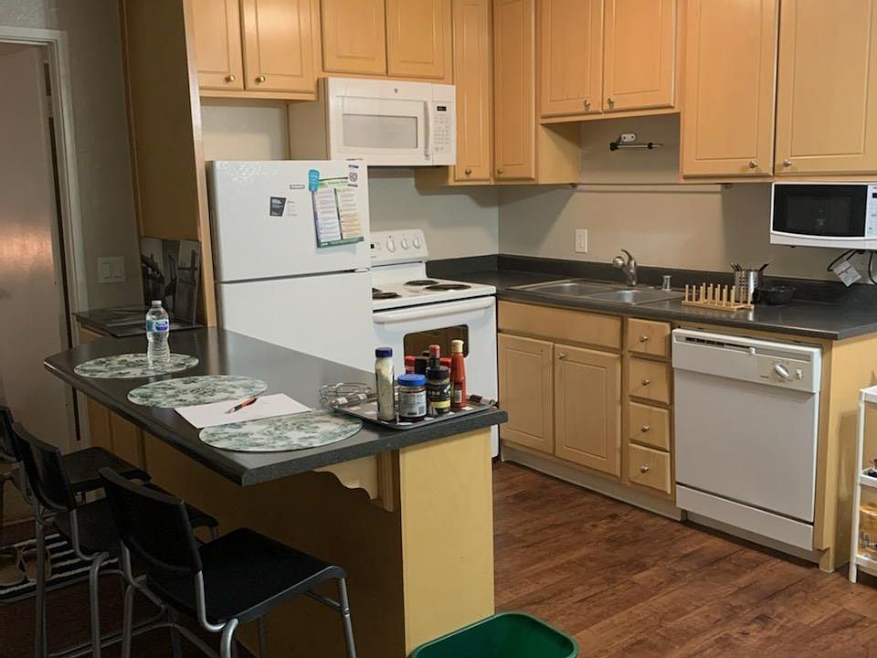 Kitchen with countertop and three bar stools (included).