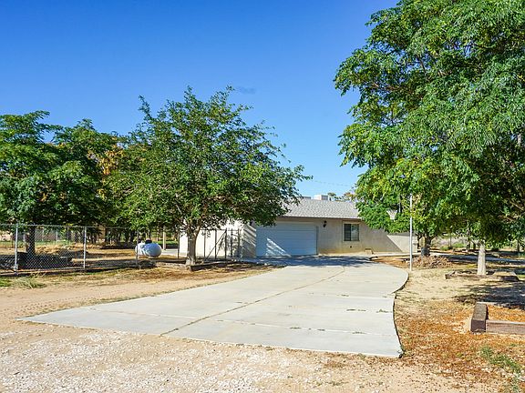Driveway to 2 car garage with basketball hoop.