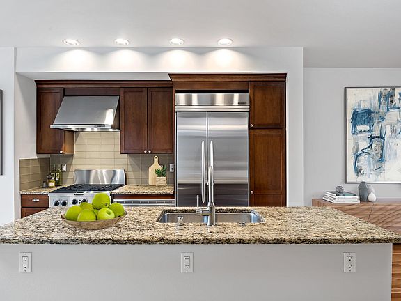 Gourmet kitchen with slab granite counters, glass tile backsplash, gas oven/range, and built-in refrigerator. Kitchen Aide appliance package. (second floor)