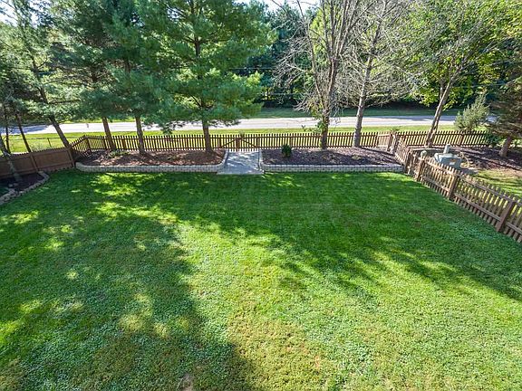 Deck Overlooks a beautifully manicured level yard & green space & small lake beyond