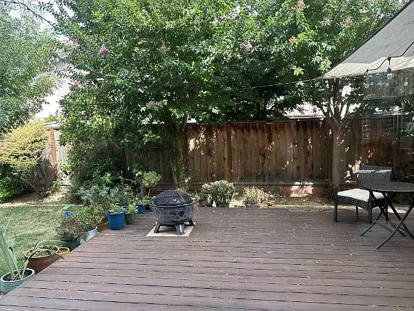 Great maintained backyard with wooden deck, small patch of grass.