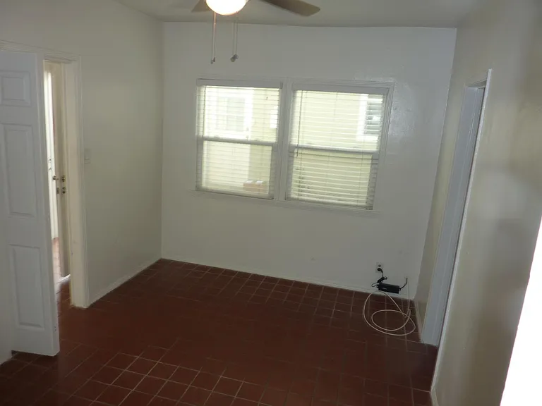 Well lit bedroom, ceiling fan with light fixture, and walk-in closet.