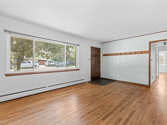 Thoughtful details include convenient wall hooks for coats and pet leashes, with the hallway leading to all three bedrooms and two full bathrooms.