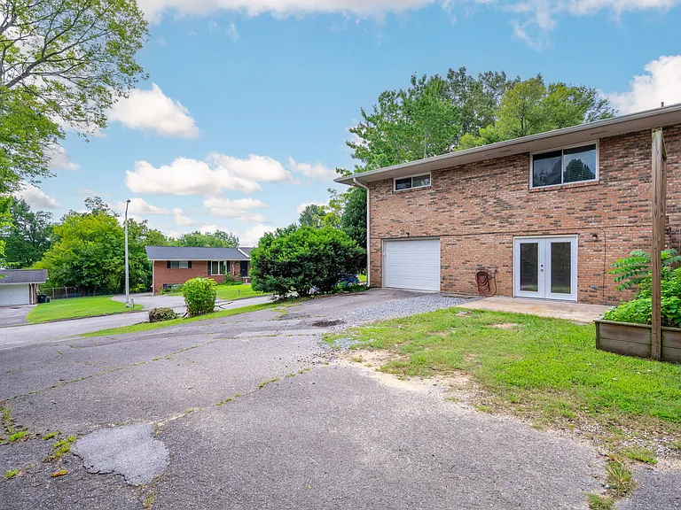 Back of Unit with garage, driveway and patio.