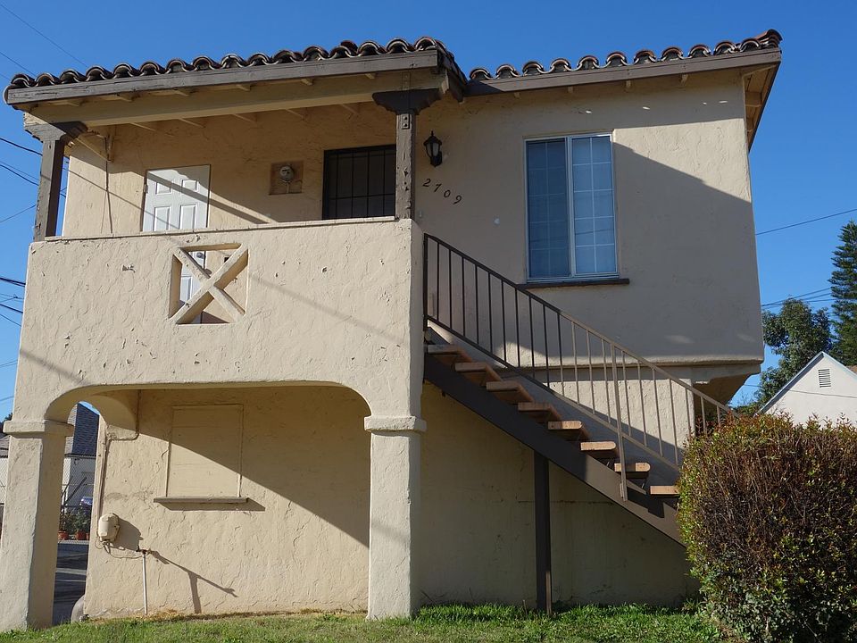 Front view of house. Entrance is up the stairs. House is abo