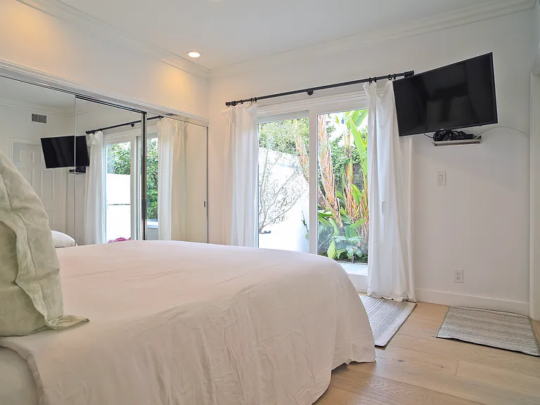 First Floor bedroom to right - King Bed with doors leading to backyard jacuzzi and Sauna.