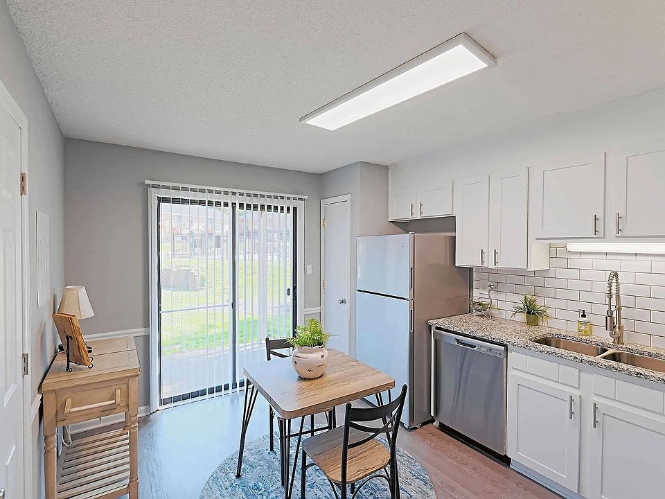 Bright eat-in kitchen with modern finishes, stainless steel appliances, and private patio access