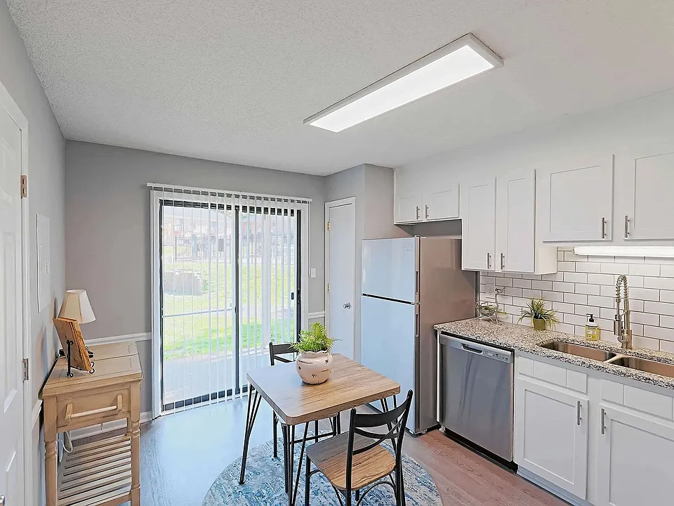Bright eat-in kitchen with modern finishes, stainless steel appliances, and private patio access