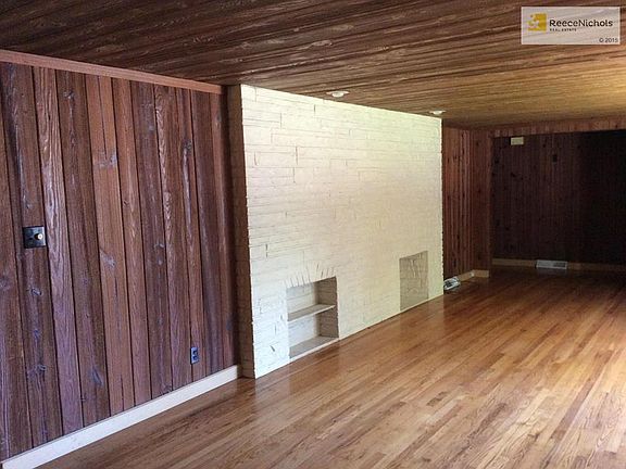 Living room has "rustic" feel with hardwood floors, real wood walls & even wood on ceiling. - fun room to decorate.