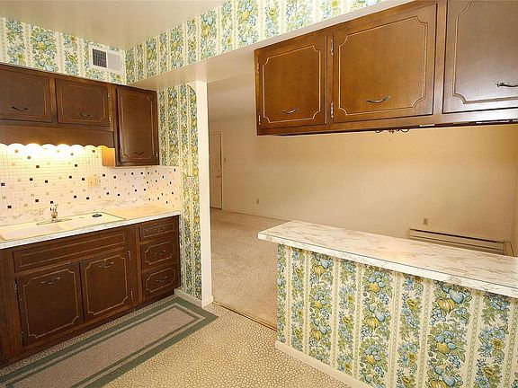 Wooden kitchen cabinets with lots of storage and counter space.  Double porcelain sink with garbage disposal.