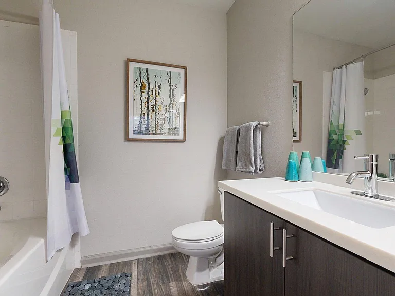 Apartment Bathroom with large soaking tub, vanity mirror and Wood-Style Flooring.