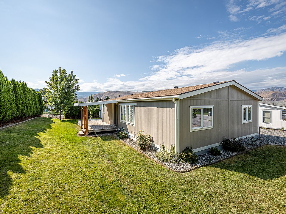 Fully-fenced backyard with covered patio, low-maintenance landscaping, automatic sprinkler-system, and irrigation water.