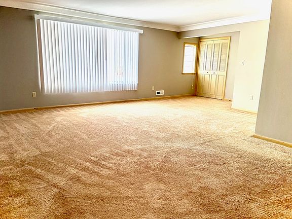 L-shaped dining and living room area carpeted