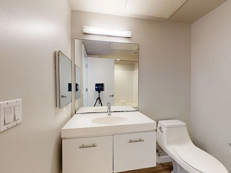Apartment bathroom with wood-style flooring.