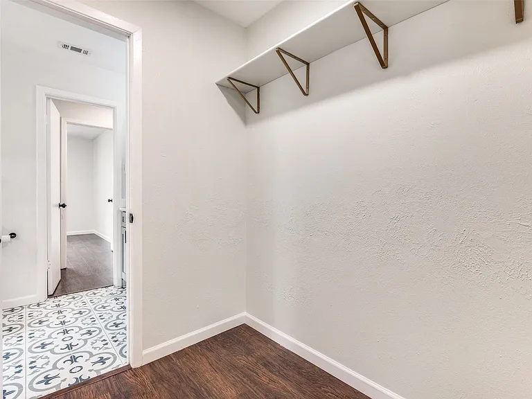 Entryway featuring wood-finish flooring, white walls, and a patterned tile accent