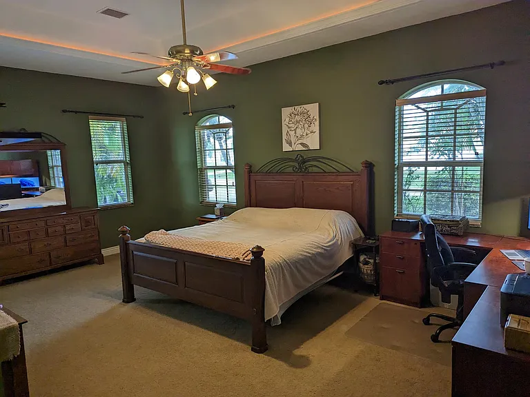 Master Suite. View from the entrance from the game room. This massive room includes recessed lighting, a ceiling fan, a separate AC from the main house, a home office workstation, a split king Sleep Number adjustable frame bed and dressers.
