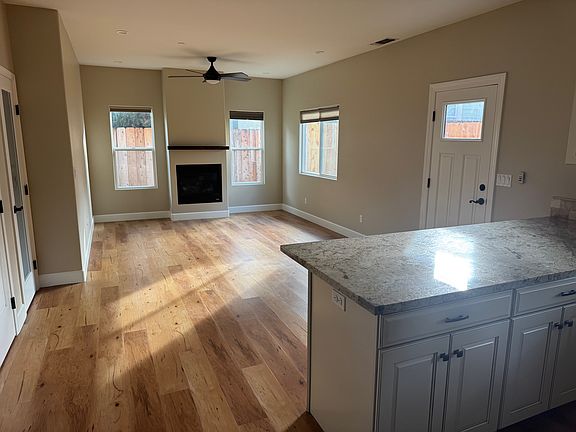 Family room, gas fireplace, lots of lighting. Door on right to back patio. Doors on left to pantry and bathroom.