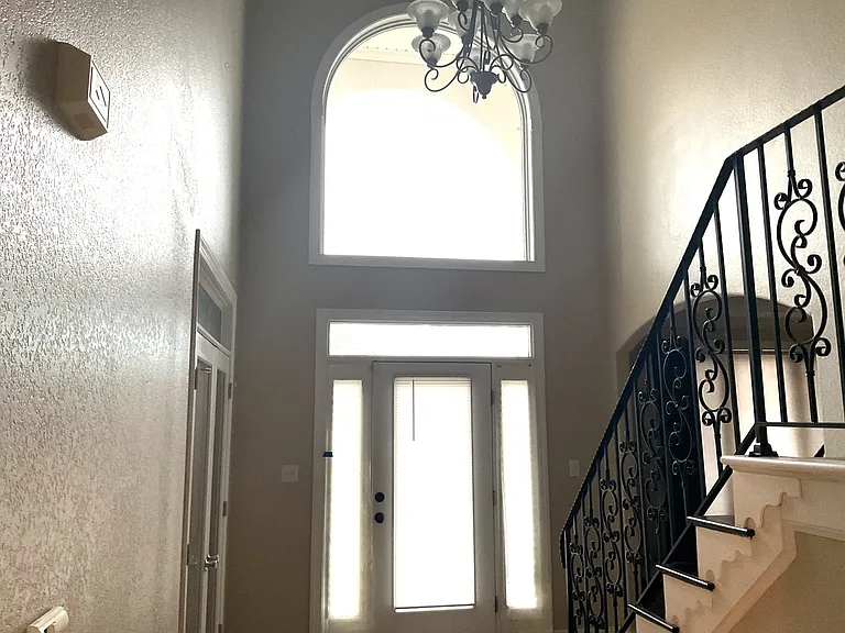 Foyer is two-stories with arched window at top