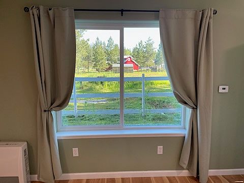 Large picture window in living room with with beautiful country view.