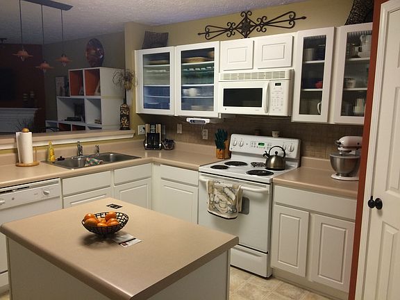 Upgraded kitchen with glass front cabinets and designer ligh