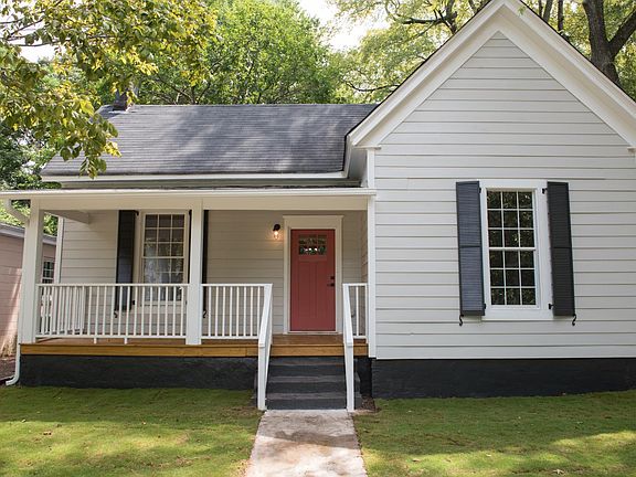 Inviting historical facade lovingly restored with recycled metal shutters. Rocking chair Porch.