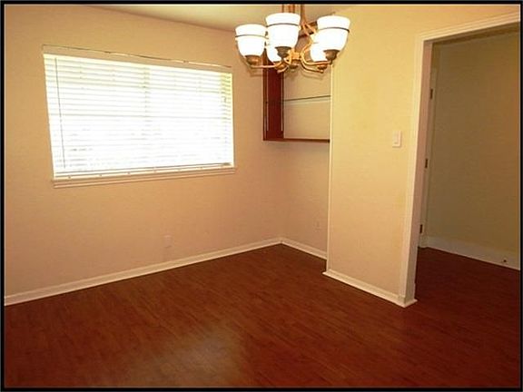 Formal dining room has laminate wood floors and built-in shelves.