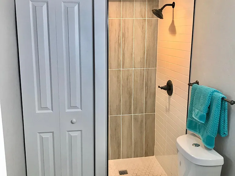 Bathroom closet contains hot water heater.