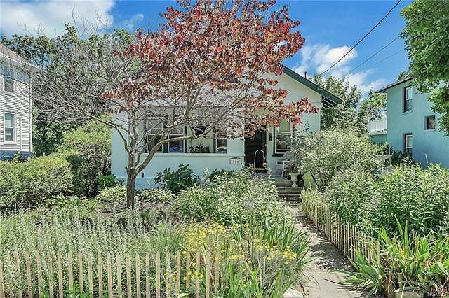 Welcome to this enchanted home in the heart of the Village with an inviting walkway to covered porch.