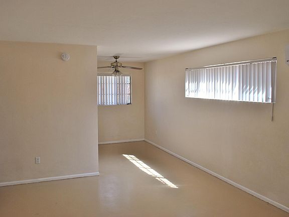 Entering the front door into the living room with space for a table under the fan off of the kitchen.
