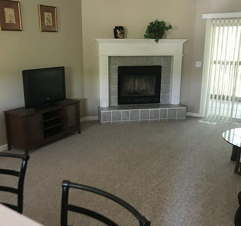 Living room, vaulted ceilings, fireplace, deck off to right.