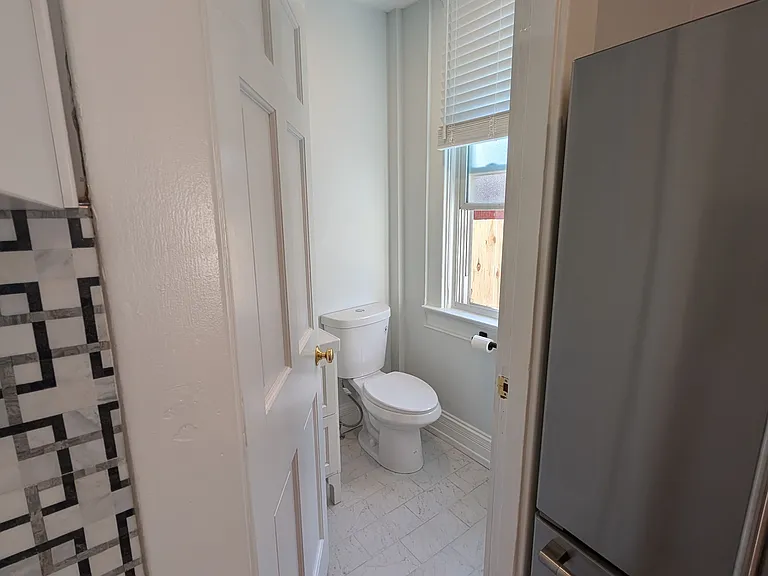 Kitchen looking into bathroom