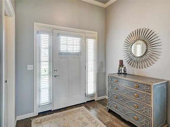 Stunning spacious entry with crown molding, wood look tile and the ever so popular color scheme.