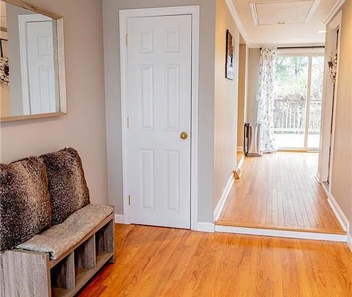View from side entryway with hall closet on left and garage entrance on right. View through to the sliders and deck overlooking the yard.