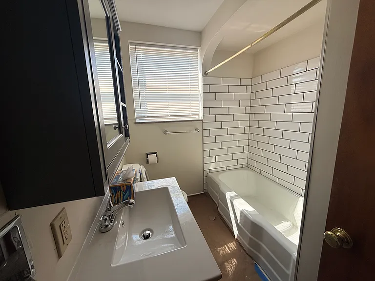 Renovated bathroom with new vanity, sink, toilet and tile surround