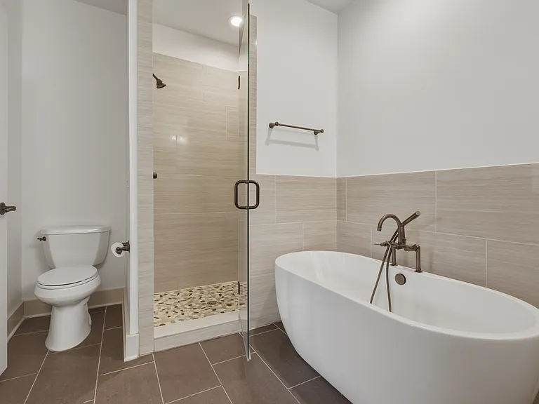 Primary bathroom attaches to the primary suite. Enjoy a double vanity with an extra cabinet for storage, soaking tub, and standing shower.