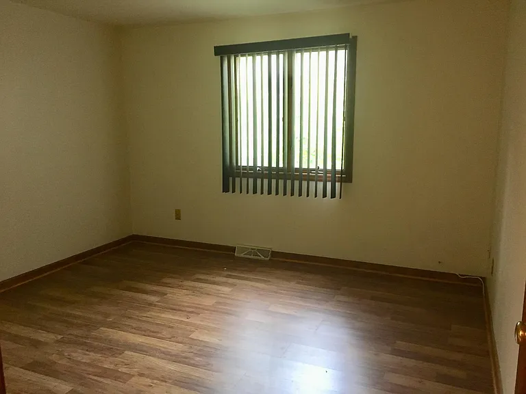 Upper bedroom with Pergo floor, custom vertical blinds, and bi-fold wardrobe closet.