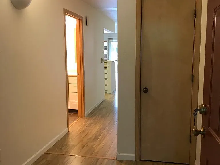 From front foyer, looking down hall into living room. Bathroom on left.