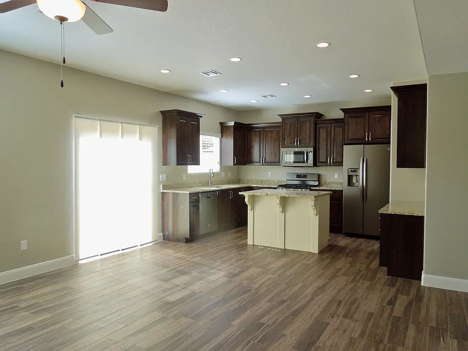 A sliding glass door opens to a large enclosed patio adjoining the common area.