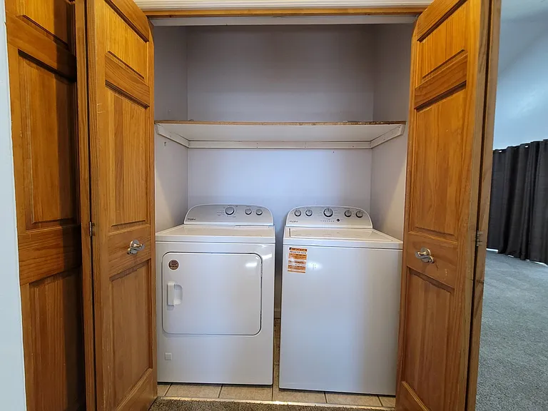 New washer and dryer in the laundry closet across from the master bedroom