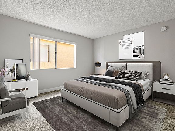 Carpeted bedroom with accent wall and large natural light window.