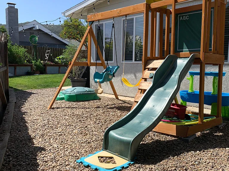 Side of backyard. Includes lovely producing orange tree. Swing set negotiable.