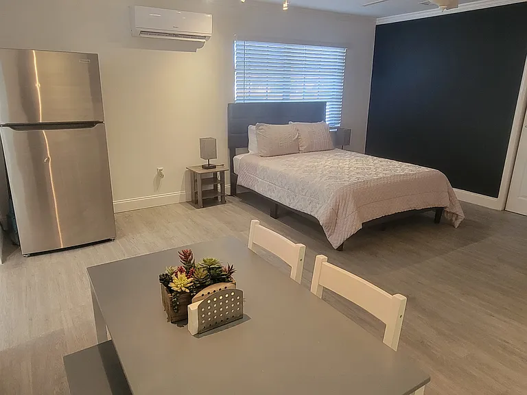 The studio includes a refrigerator, dining area, and air conditioning for added comfort.