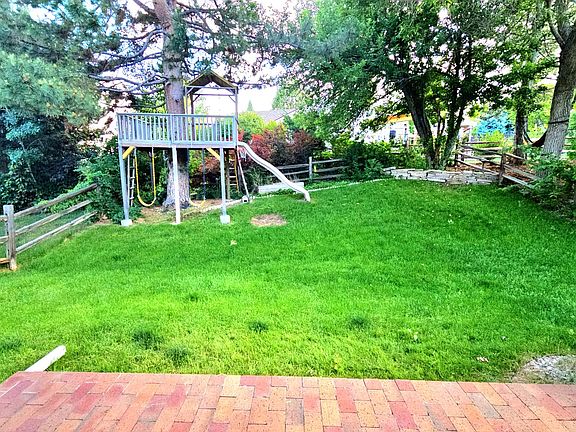 Backyard with treehouse and multiple grown trees