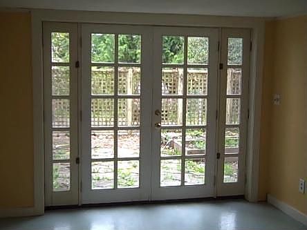 Basement french doors look out onto patio, raised garden bed