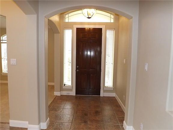The foyer is spacious and has tile flooring which leads into the family area and crown molding.