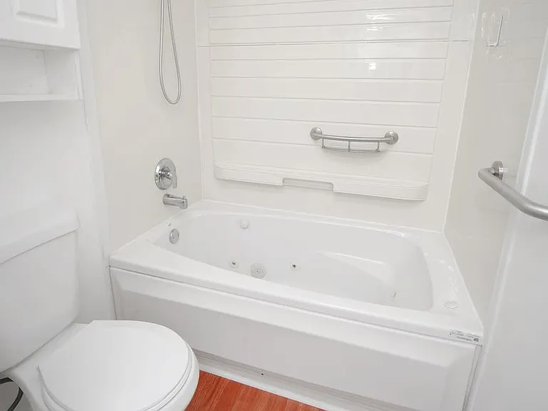 Bathroom - Tub (whirlpool-jacuzzi) and toilet with cabinet.