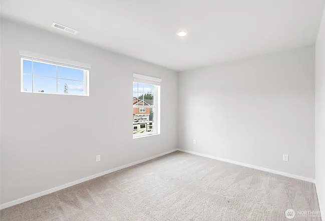 3rd Bedroom with large windows and front yard views.